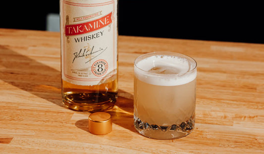 A Whiskey Sour cocktail and a bottle of Takamine 8-Year Koji-Fermented Whiskey